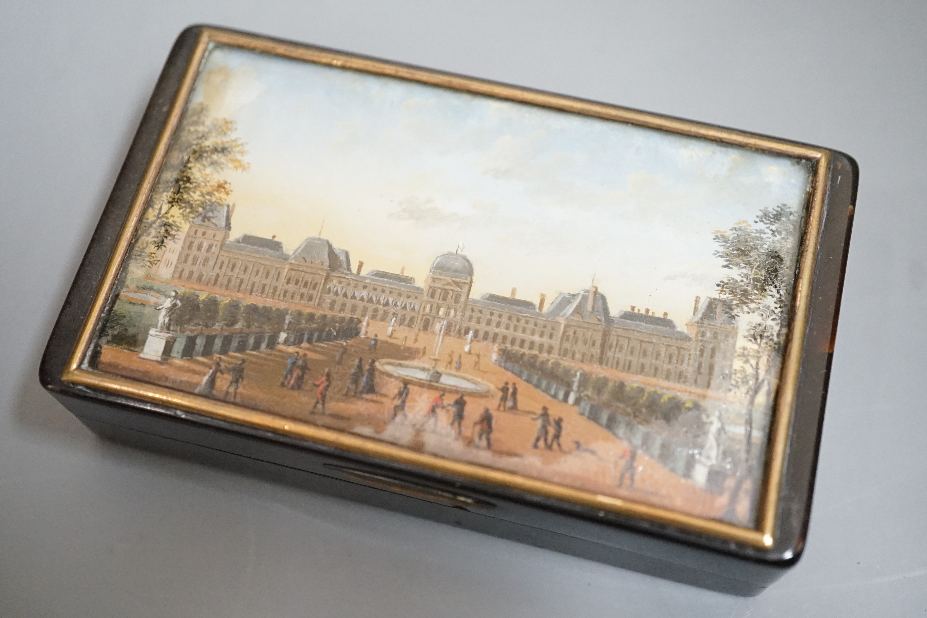 A 19th century French tortoiseshell snuff box, the top with reverse painted glass scene Tuileries Palace, Paris, J F Lebell, 9cms wide x 5.5cms